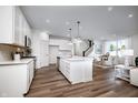 Open concept kitchen with white cabinets, island, and hardwood floors at 5505 Noble Crossing W Pkwy, Noblesville, IN 46062