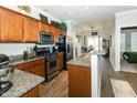 Well-lit kitchen featuring stainless steel appliances, granite countertops, wooden cabinets and an open design that flows into the dining area at 6595 Reserve Dr, Indianapolis, IN 46220