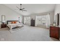 Bright main bedroom with neutral colors, carpet floors, ceiling fan, and large windows overlooking neighborhood at 6595 Reserve Dr, Indianapolis, IN 46220