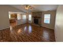 Spacious living room featuring hardwood floors, a stone fireplace, and an open kitchen view at 9120 Jene Ct, Indianapolis, IN 46234