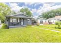 Charming home featuring a covered front porch and a well-manicured lawn, set in a cozy neighborhood at 1704 Nelson Ave, Indianapolis, IN 46203