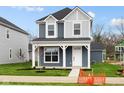 Charming two-story home featuring a covered porch, blue siding, and a well-maintained lawn at 1705 Real St, Indianapolis, IN 46240