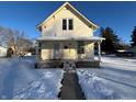 Charming yellow house with snow-covered yard and front porch at 325 S Market St, Thorntown, IN 46071