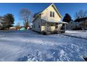 House exterior showcasing a snowy yard and chain link fence at 325 S Market St, Thorntown, IN 46071