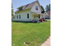 Charming two-story home with a spacious lawn and a quaint front porch, perfect for relaxing at 325 S Market St, Thorntown, IN 46071