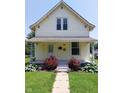 Charming two-story home with inviting front porch adorned with lush red roses and greenery at 325 S Market St, Thorntown, IN 46071