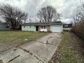 House exterior featuring green siding, a driveway, and landscaping at 4219 E 43Rd Ct, Indianapolis, IN 46226