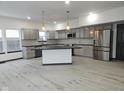 Modern kitchen featuring gray cabinets, marble countertops, and a large island at 5748 Glass Chimney Ln, Indianapolis, IN 46235