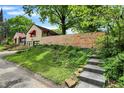 View of home and yard featuring wooden privacy fence, garden beds, and stone steps at 6072 Meridian St W Dr, Indianapolis, IN 46208