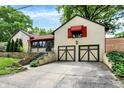 A beautiful home featuring a 2 car garage, red awnings, and lush landscaping at 6072 Meridian St W Dr, Indianapolis, IN 46208