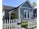 Gray home with a white picket fence, offering curb appeal and a cozy neighborhood feel at 630 E Mccarty St, Indianapolis, IN 46203