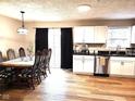 Bright and spacious kitchen and dining area with white cabinetry and wood flooring at 9812 W 900 N Rd, Elwood, IN 46036