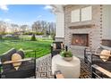 Cozy covered patio with a fireplace, comfortable seating, and a view of the beautifully landscaped yard at 11430 Aubrey Ln, Fishers, IN 46040