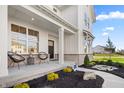 Inviting front porch with comfortable seating and attractive landscaping leading up to the main entrance at 11430 Aubrey Ln, Fishers, IN 46040