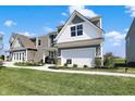 Beautiful two-story home featuring gray and white siding, a two-car garage, and attractive landscaping at 11620 Hartwell St, Indianapolis, IN 46235