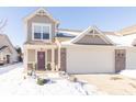 Two-story townhouse with attached garage, snow-covered landscaping, and charming front entrance at 1226 Arlington Dr, Greenfield, IN 46140