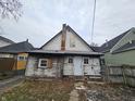 Rear exterior showcasing weathered siding, outdated fixtures, and a chimney at 1601 Spann Ave, Indianapolis, IN 46203