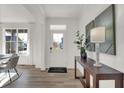 Bright foyer with wood floors, white door, console table, artwork, and abundant natural light at 19452 Lewis Cir, Westfield, IN 46074