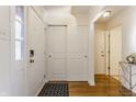 Bright entryway with hardwood floors, white doors, and a small table at 30 Village Ct, Zionsville, IN 46077