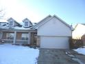 Brick and gray siding ranch home with a two-car garage and snowy front yard at 316 Society Dr, Indianapolis, IN 46229