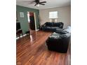 Living room with hardwood floors, neutral walls and black leather couches at 3355 Wallace Ave, Indianapolis, IN 46218