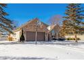 Brick home with basketball hoop, snow-covered yard, and mature trees at 5105 S Montego Way, Muncie, IN 47302