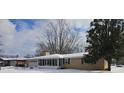 Brick ranch home with a snow covered yard and attached garage at 515 Wedgewood Dr, Anderson, IN 46013
