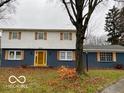 Newly painted two-story house with blue and white exterior, shutters, and a yellow door at 810 Kendale Ct, Indianapolis, IN 46234