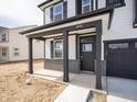 Covered front porch with black columns, brick accents, and a glass-paneled front door at 8798 Walker St, Fortville, IN 46040