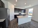 Modern kitchen with dark cabinetry, quartz countertops island, and stainless steel appliances at 8798 Walker St, Fortville, IN 46040