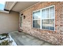 Brick front porch with a window and exterior light fixture at 10565 Camille Ct, Indianapolis, IN 46236