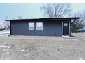 Modern single story home with dark siding and a black front door at 1384 Cross St, Martinsville, IN 46151