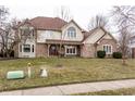Beautiful two-story home featuring brick and siding, mature trees, and a green lawn at 13955 Springmill Ponds Cir, Carmel, IN 46032
