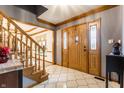 Elegant foyer with a wooden staircase, tile flooring, and a double-door entry at 13955 Springmill Ponds Cir, Carmel, IN 46032