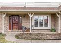 Inviting covered porch with seating, a decorative front door, and brick accents at 13955 Springmill Ponds Cir, Carmel, IN 46032