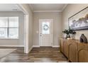 Inviting foyer with wood floors, a stylish console table, and a decorative art piece at 5442 W Turnbuckle Pl, McCordsville, IN 46055
