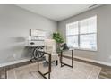 Bright office space with a glass desk, comfortable chair, and natural light from a large window at 5442 W Turnbuckle Pl, McCordsville, IN 46055