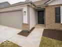 Close-up of the home's entrance with a two-car garage, stone accents, and walkway at 6618 Sulgrove Pl, Indianapolis, IN 46221