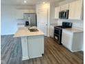Modern kitchen featuring stainless steel appliances, a center island and white cabinetry at 6618 Sulgrove Pl, Indianapolis, IN 46221