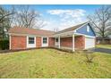 Brick ranch home with a blue accent and attached garage at 7817 Dartmouth Rd, Indianapolis, IN 46260