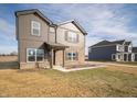 Beautiful two-story home with brown siding, brick, landscaped front, and a neighboring house under a bright sky at 7872 Magnolia St, New Palestine, IN 46163