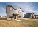 View of a modern two-story home with brown siding, brickwork, and a neatly maintained front yard at 7872 Magnolia St, New Palestine, IN 46163