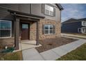 Close-up view of a home's front entry featuring brick pillars and a dark-stained front door at 7872 Magnolia St, New Palestine, IN 46163
