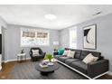 Bright living room featuring comfy gray sofa and arm chair at 837 Birch Ave, Indianapolis, IN 46221
