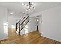 Bright entryway with hardwood floors, staircase, and chandelier at 10322 Buell Ct, Avon, IN 46123