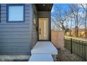 Welcoming front entrance featuring a concrete porch, modern door, and sleek dark gray exterior paneling at 1656 Roosevelt Ave, Indianapolis, IN 46218