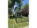 Charming two-story home with a well-maintained lawn and a classic black fence at 1656 Roosevelt Ave, Indianapolis, IN 46218