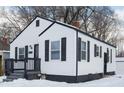 White house with black accents and snowy yard. Side view at 3501 Caroline Ave, Indianapolis, IN 46218