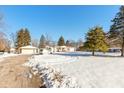 House with a large yard, detached garage, and driveway, covered in snow at 4202 W Mooresville Rd, Indianapolis, IN 46221