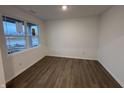 Cozy room featuring wood-look floors, a large window, and neutral white paint at 5133 Cartland Dr, Indianapolis, IN 46239